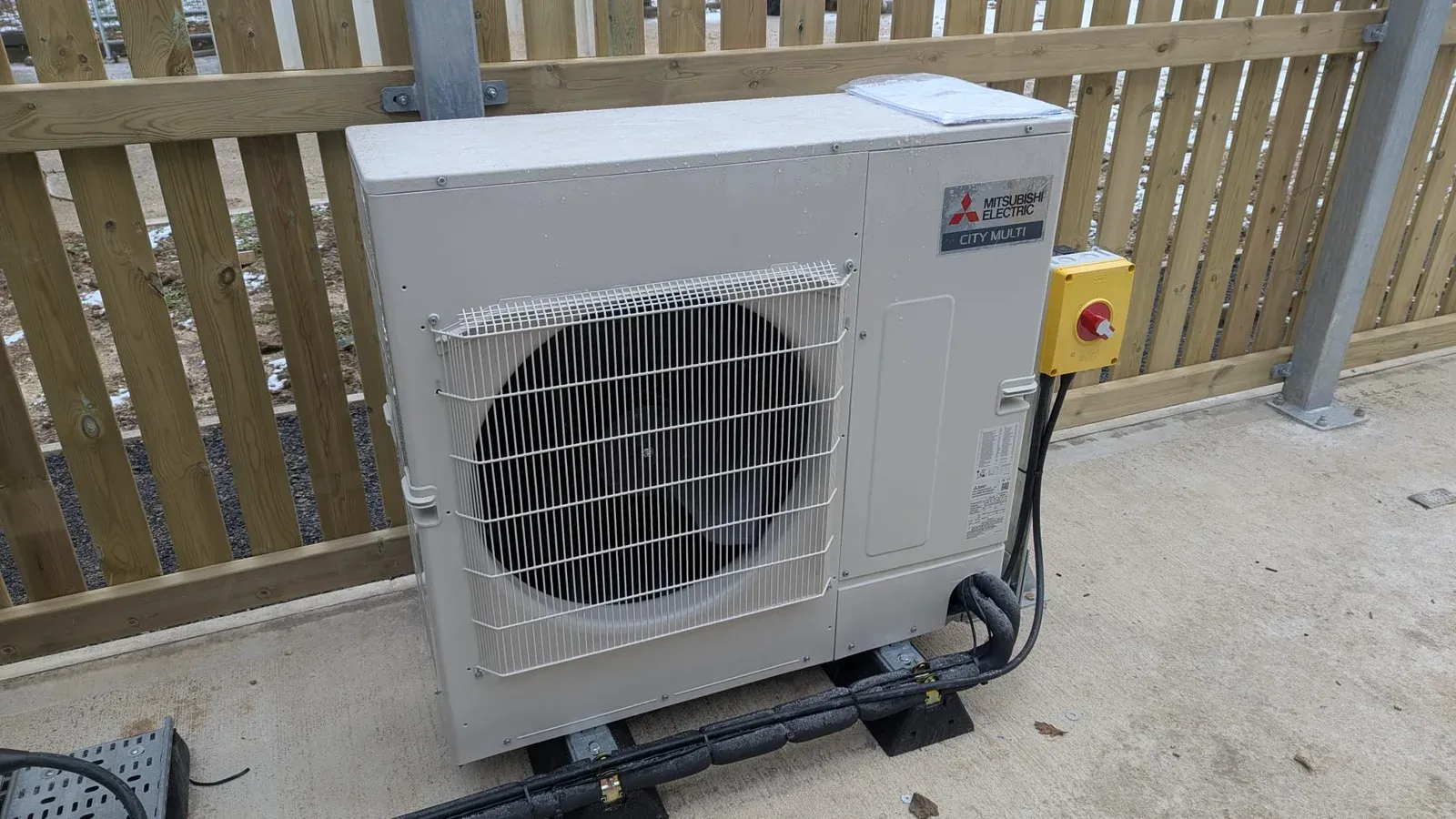 Mitsubishi Electric outdoor unit with insulated pipework and an electrical isolator